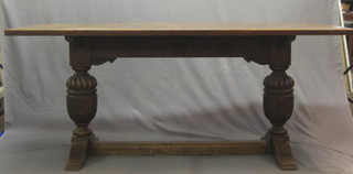 An oak refectory style dining table raised on bulbous turned supports with H framed stretcher 72"