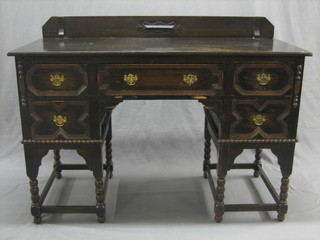 A Victorian Jacobean style oak writing table/dressing table, fitted 1 long drawer flanked by 4 short drawers, raised on turned and block supports 48"