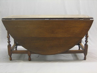 An 18th Century oak oval drop flap gateleg dining table, fitted a frieze drawer and raised on turned supports 57"