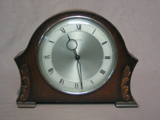 A 1950's 8 day mantel clock with silver dial and Roman numerals contained in an oak arch shaped case