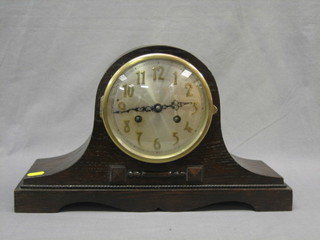 A 1930's chiming 8 day mantel clock with silvered dial and Arabic numerals contained in an oak Admiral's hat shaped case