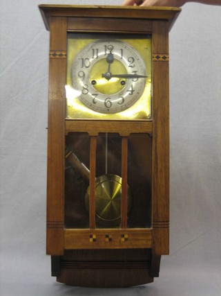 An Art Nouveau striking wall clock with square brass dial and silvered chapter ring contained in an oak case