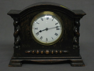 A 1930's French 8 day bedroom timepiece with enamelled dial and Roman numerals contained in an arch shaped oak case with spiral turned decoration