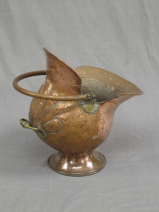 A planished copper helmet shaped coal scuttle