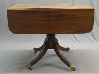 A 19th Century mahogany pedestal Pembroke table fitted a frieze drawer, raised on a turned column and tripod base ending in brass caps and castors 36"