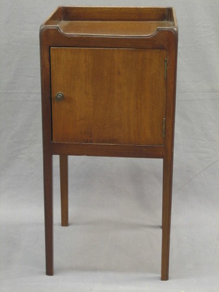 A Georgian style mahogany tray top commode enclosed by a panelled door, raised on square tapering supports 14"
