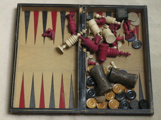 A 30 piece white and red carved ivory chess set comprising 2 red castles, King and Queen, 2 red Bishops, 10 pawns (2 f), 2 white castles, King and Queen, 2 white Bishops, 2 rooks, 6 pawns, all contained in a games compendium set, together with a part wooden Backgammon set with 2 die shakers