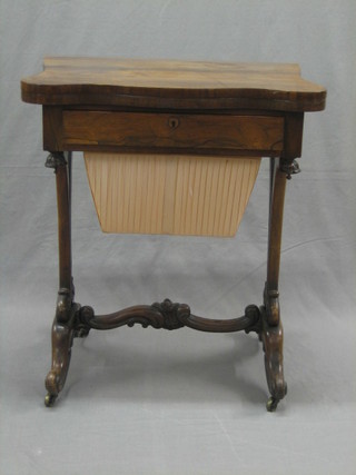 A William IV rosewood work table of serpentine outline and flip over top, inlaid leather, the base fitted 1 long drawer above a deep basket, raised on pierced panelled supports with scrolled feet 24"