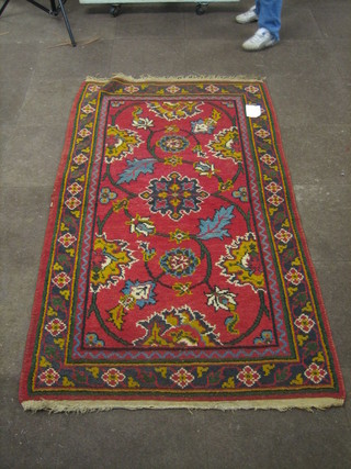 A red ground and floral patterned Afghan/Indian rug 77" x 46"