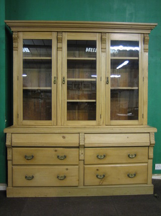 A 19th Century pine triple bookcase on cabinet with moulded cornice, the interior fitted adjustable shelves, the base fitted 2 long secret drawers above 4 long drawers 72"