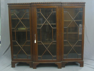 A 1940's Chippendale style mahogany break front display cabinet with gadrooned border, the interior fitted adjustable shelves enclosed by astragal glazed panelled doors, raised on bracket feet 55"
