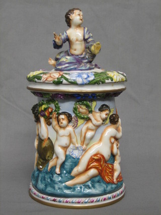 A Capo di Monte oval trinket box, the body decorated various figures, the lid with finial in the form of a seated boy (R and some chips) 10"
