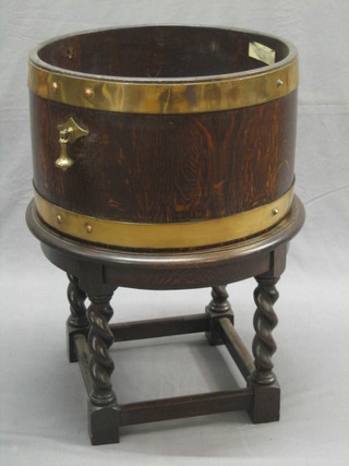 A coopered oak planter with brass drop handles, raised on a turned and block supports 18"