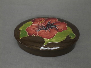 A Moorcroft oval chocolate pot, the lid painted a pink Hibiscus with impressed Moorcroft mark Made in England, 1942, 4 1/2"
