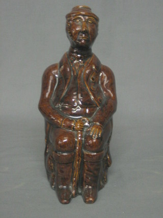 A 19th Century treacle glazed bottle in the form of a seated gentleman 9"