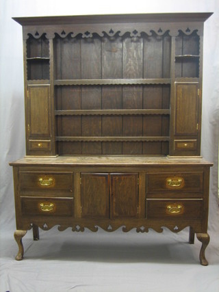 A 19th Century oak dresser with carved and pierced cornice, the back fitted 3 drawers flanked by cupboards with drawers beneath, the crossbanded base fitted a cupboard to the centre flanked by 4 short drawers, raised on cabriole supports 62"