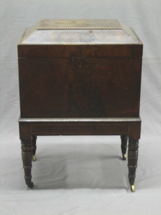 A Georgian mahogany cellarette of sarcophagus form, the interior fitted 3 metal compartments, having a hinged lid and ring handles to the sides, raised on turned supports 19"