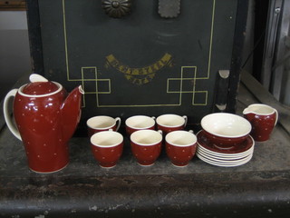 A 1950's 9 piece Susie Cooper coffee set comprising coffee pot, sugar bowl, cream jug, 6 coffee cups and saucers with red ground and crescent decoration, the base marked Susie Copper Productions Crown Works Burslem