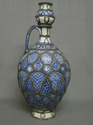 An Eastern blue and white pottery jug with applied metal decoration 24"
