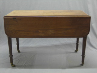 A Victorian bleached mahogany Pembroke table fitted a frieze drawer, raised on turned supports ending in brass caps and castors 44"