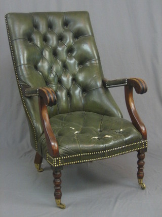 A William IV style mahogany open arm library chair upholstered in green buttoned leather