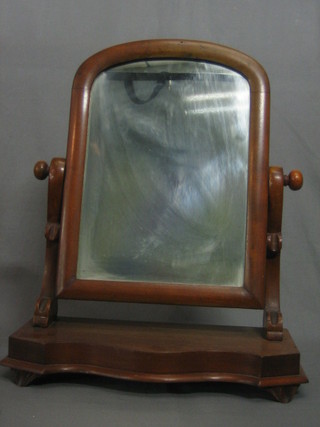 A Victorian arched plate dressing table mirror contained in a mahogany swing frame, raised on serpentine base 15"