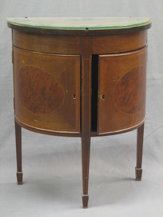 A 20th Century Georgian style inlaid mahogany demi-lune cabinet fitted cupboards and enclosed by panelled doors, raised on square tapering supports ending in spade feet 23"