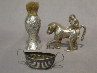 A Victorian embossed silver shaving brush, a silver figure of a walking "monkey", a miniature silver twin handled salt and a thimble (4)