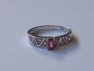 A 9ct white gold dress ring set pink sapphires supported by other sapphires