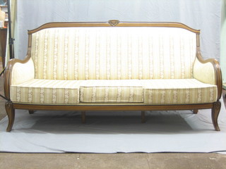 A Continental walnut show frame 3 seat settee raised on cabriole supports upholstered in striped material 75"