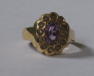 A Victorian 18ct gold dress ring set an oval cut amethyst supported by demi-pearls