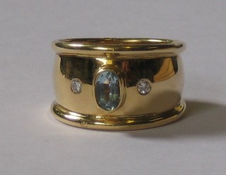 An 18ct gold ring set an oval cut aquamarine supported by 2 diamonds