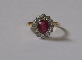 A lady's 18ct yellow gold dress ring set an oval cut ruby supported by numerous diamonds