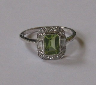 A lady's 18ct white gold dress ring set a rectangular cut peridot and 2 baguette cut diamonds surrounded by numerous small diamonds approx 1.07ct
