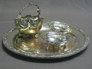 A circular silver plated salver with cast body 11 1/2", 2 oval silver plated salts 4" and a shaped silver plated sugar bowl with sifter spoon
