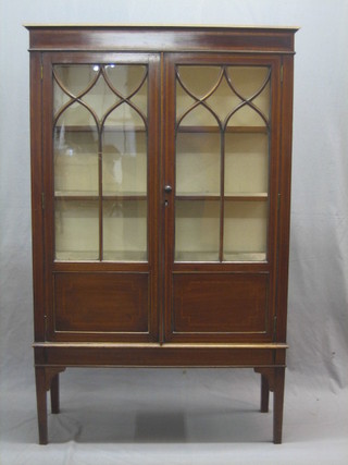 An Edwardian inlaid mahogany display cabinet with moulded cornice, fitted shelves enclosed by astragal glazed panelled doors, raised on square tapering supports 36" 