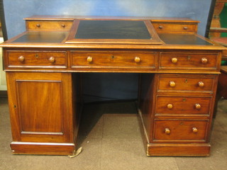 A Victorian mahogany kneehole pedestal desk the raised back fitted 2 drawers with hinged writing surface above 3 short drawers, the pedestal fitted a cupboard and 3 long drawers 55"