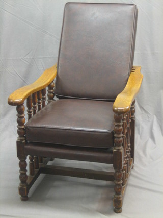 A pair of 1920's honey oak reclining arm chairs with turned decoration to the sides