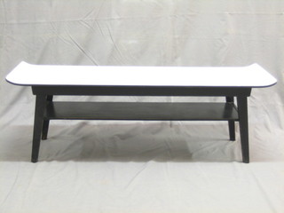 A 1950's G Plan ebonised coffee table with scroll shaped top 44"