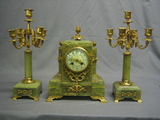 A French 19th Century onyx and ormolu clock set comprising striking mantel clock with enamelled dial and Arabic numerals contained in a gilt onyx case together with two 5 light candelabrum
