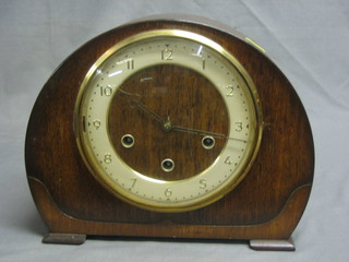 A 1930's chiming mantel clock with Arabic numerals contained in an arch shaped mahogany case