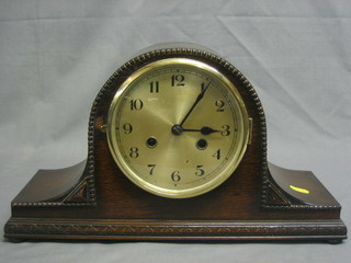 A striking mantel clock with silvered dial and Arabic numerals contained in an oak Admirals hat shaped case