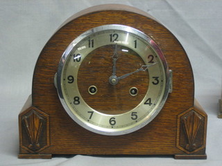 A striking mantel clock with silver dial and Arabic numerals contained in an oak case