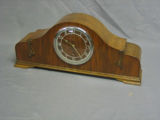 An Art Deco mantel clock with Arabic numerals contained in an arch shaped walnut case