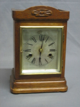 A 19th Century striking mantel clock with rectangular silver dial and Arabic numerals contained in an oak case