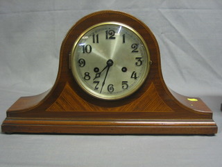 A striking mantel clock with silvered dial and Arabic numerals contained in an inlaid mahogany Admiral's hat shaped case