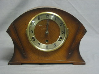A 1930's chiming mantel clock with silvered dial and Arabic numerals contained in an arch shaped oak case