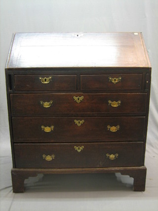 An 18th Century oak bureau, the fall front above 2 short and 3 long drawers, raised on bracket feet 36"