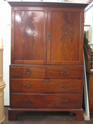 A 19th Century mahogany linen press with moulded and dentil cornice, the interior fitted trays enclosed by panelled doors (crack to 1 panel), the base fitted 2 short and 2 long drawers raised on bracket feet 51"