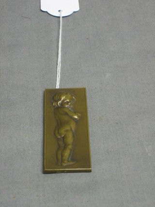 A bronze plaque in the form of a standing girl 3" x 1"